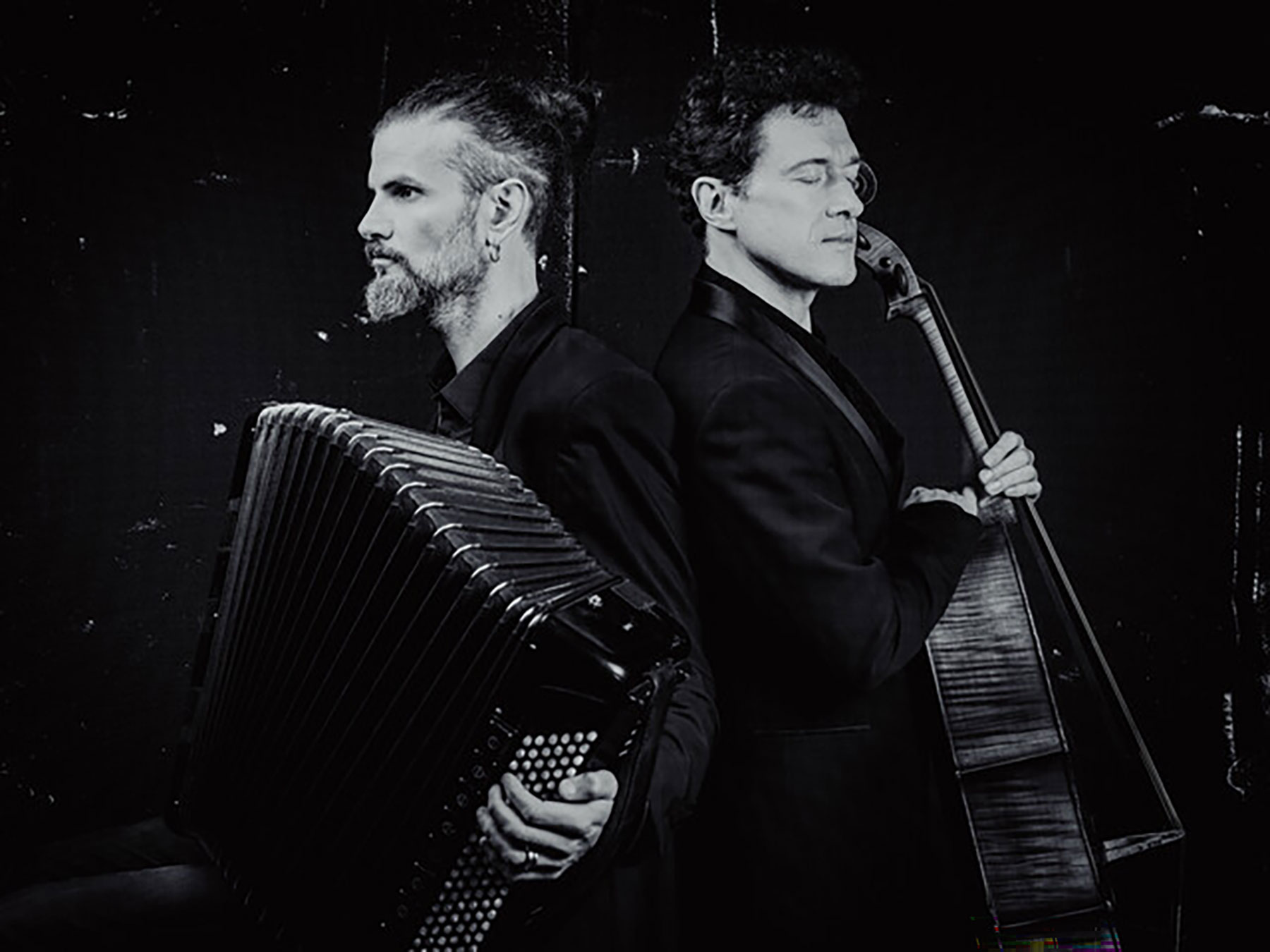 Cette photo en noir et blanc présente les deux artistes dos à dos, chacun avec son instrument.