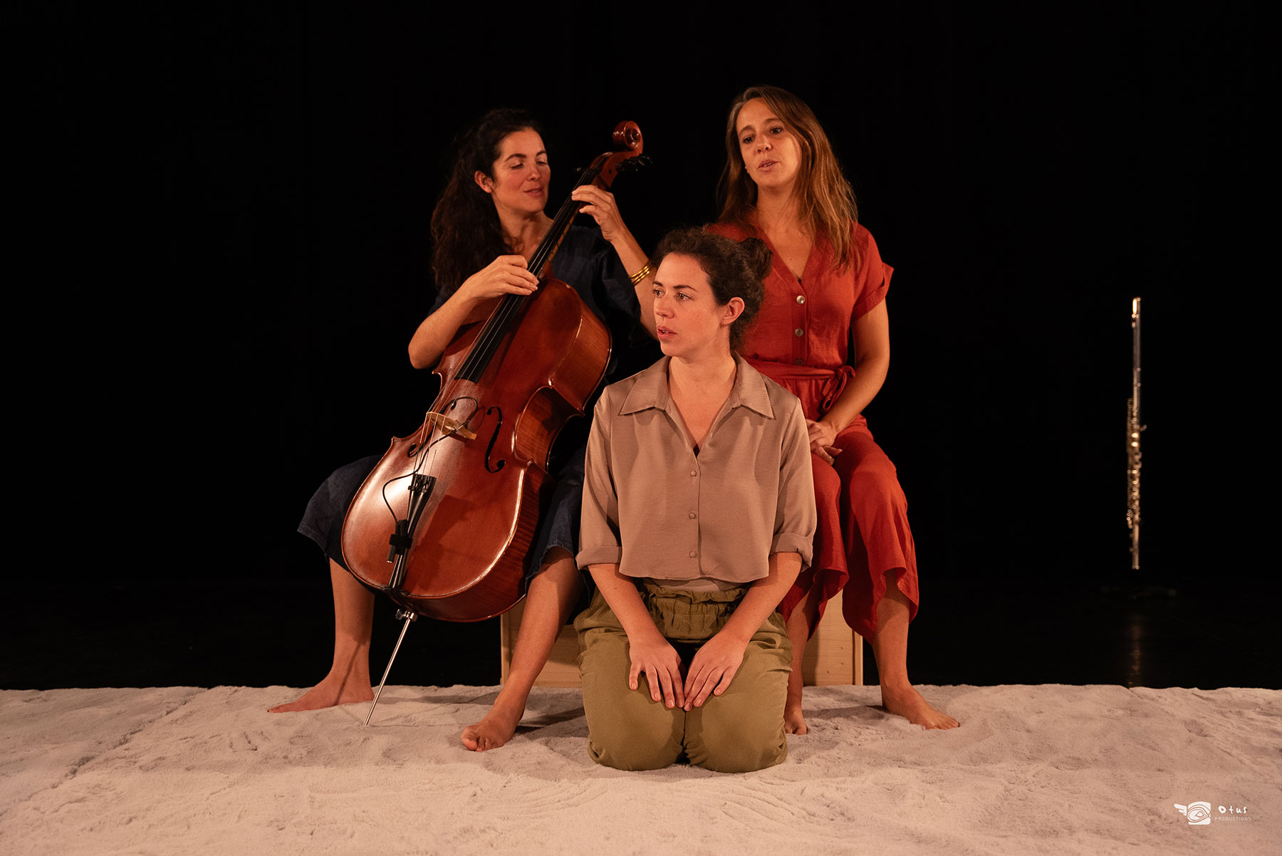 On voit les 3 chanteuses musiciennes avec le violoncelle, dans une lumière douce et chaleureuse